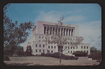 The image shows the front exterior of a Neoclassical style building with Art Moderne influences viewed at an angle from the left and slightly below. The building has seven floors.