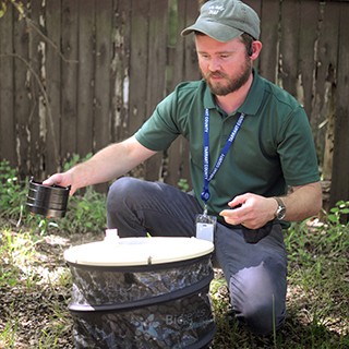 Sanitarian inspecting a mosquito trap in remote location
